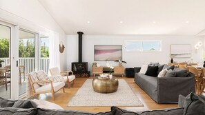 A spacious living room with a sofa, chairs, a coffee table, and a fireplace.