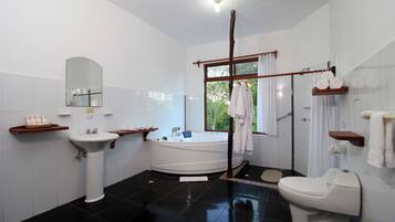 A modern bathroom with a bathtub, toilet, sink, and a large mirror.