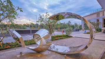 A modern sculpture with a reflective surface in an outdoor plaza.