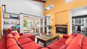 A spacious living room with red sofas, a fireplace, and a bookshelf. - 185 Sud  relax and enjoy Menorca (Son Parc)