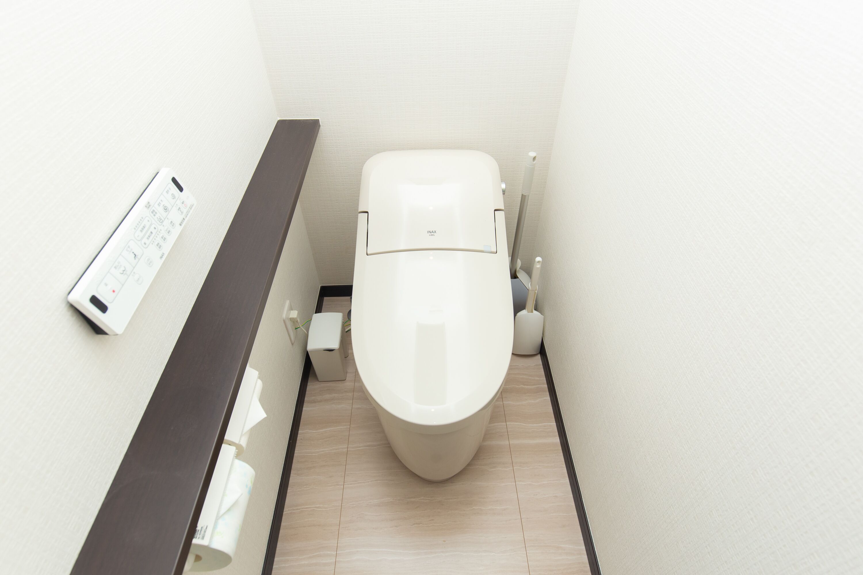 Un baño moderno con inodoro, secador de manos y dispensador de toallas de papel.