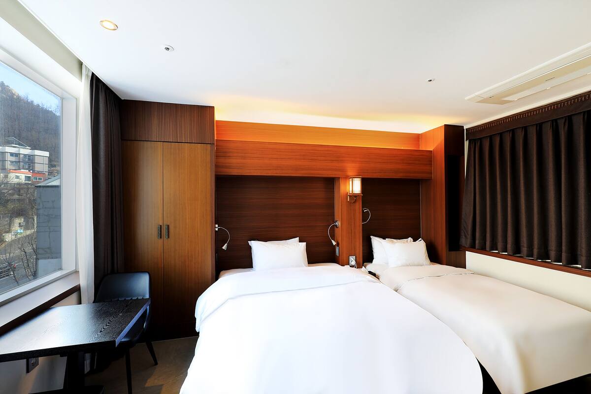 Una habitación de hotel con una cama grande, un escritorio y un armario.