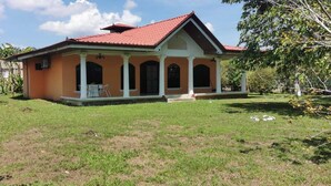 A single-story house with a red roof and a porch with white columns.