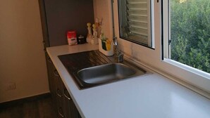 A kitchen with a large window, a sink, and cabinets. - Il Casello Country House  (Sciacca)