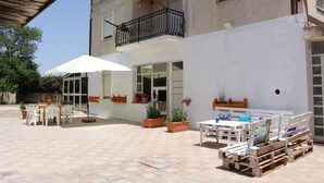 A courtyard with outdoor seating, potted plants, and a pool area. - Il Casello Country House  (Sciacca)
