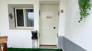 A white door with a 'Welcome' sign, a small window, and a potted plant beside it. - Il Casello Country House  (Sciacca)