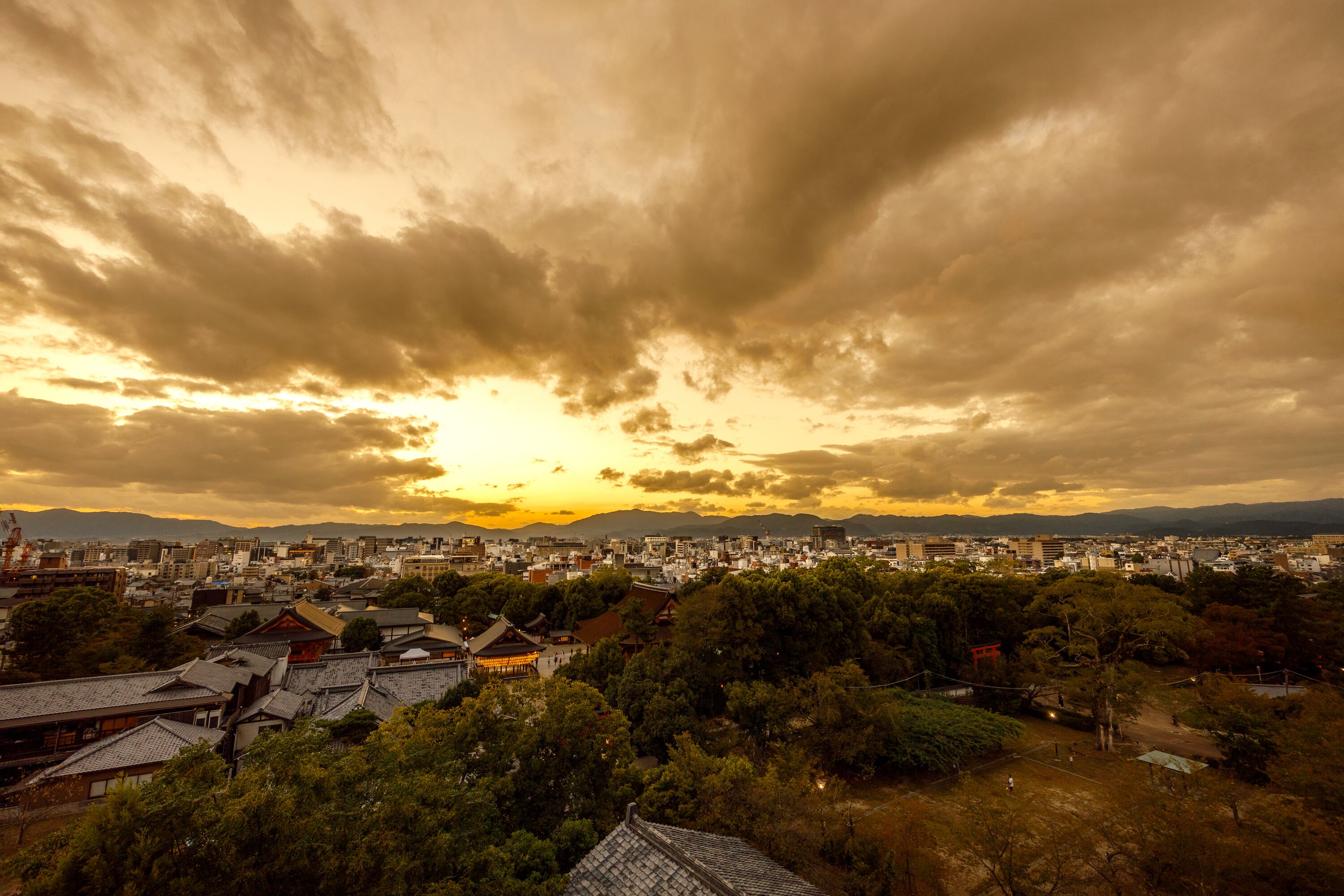 A cityscape with traditional architecture and a sunset.