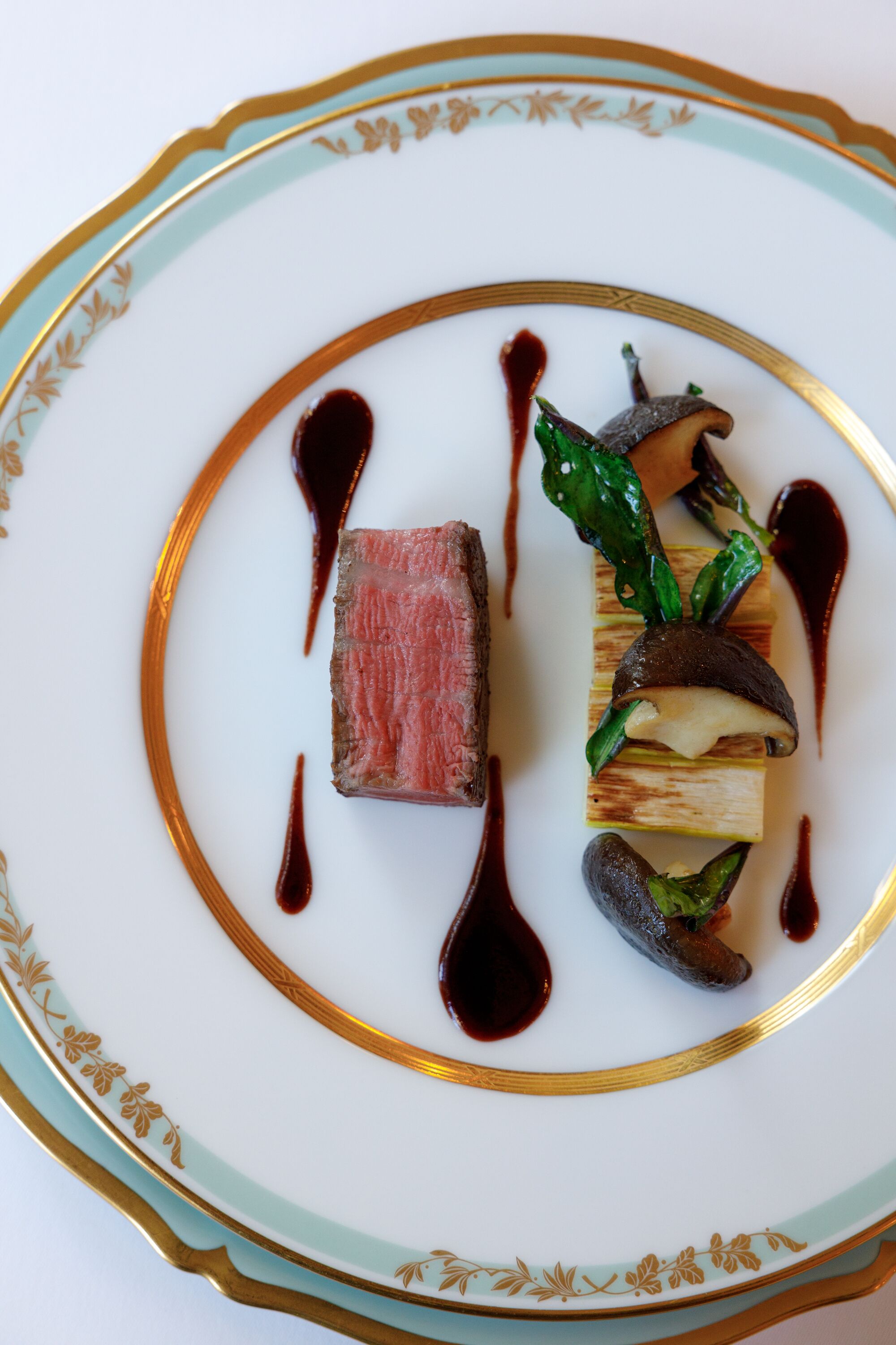 A plate with a dish featuring meat, vegetables, and sauce.
