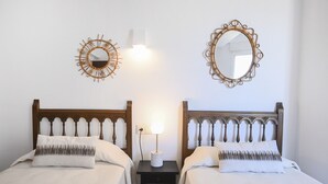 A hotel room with two single beds, each with a wooden headboard and a white bedspread. There are two wall-mounted mirrors and a small table with a lamp between the beds. - A84 CALPE TOWER 3-10 (Calpe)