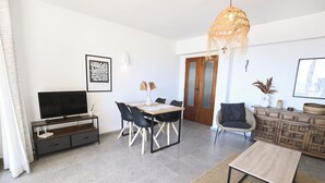 A modern living room with a TV, dining table, chairs, and a sofa. - A84 CALPE TOWER 3-10 (Calpe)