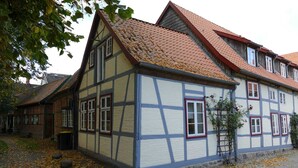 Ett traditionellt hus med korsvirkesfasad, brant tak och många fönster.