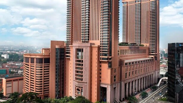 Un edificio de gran altura con un diseño arquitectónico moderno, con varios balcones y un área de entrada destacada.