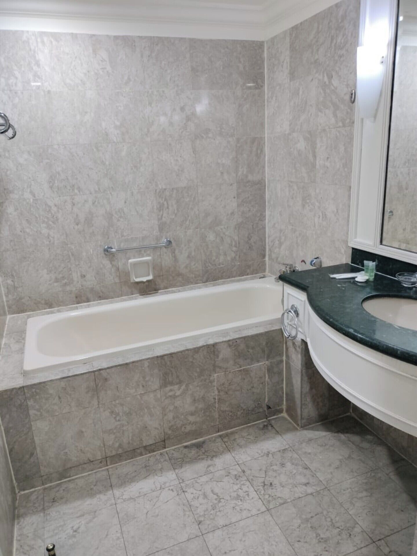 Une salle de bain avec une baignoire, un lavabo et un miroir.