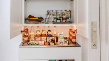 Un petit réfrigérateur doté de plusieurs étagères, contenant divers aliments, condiments et articles de verrerie.