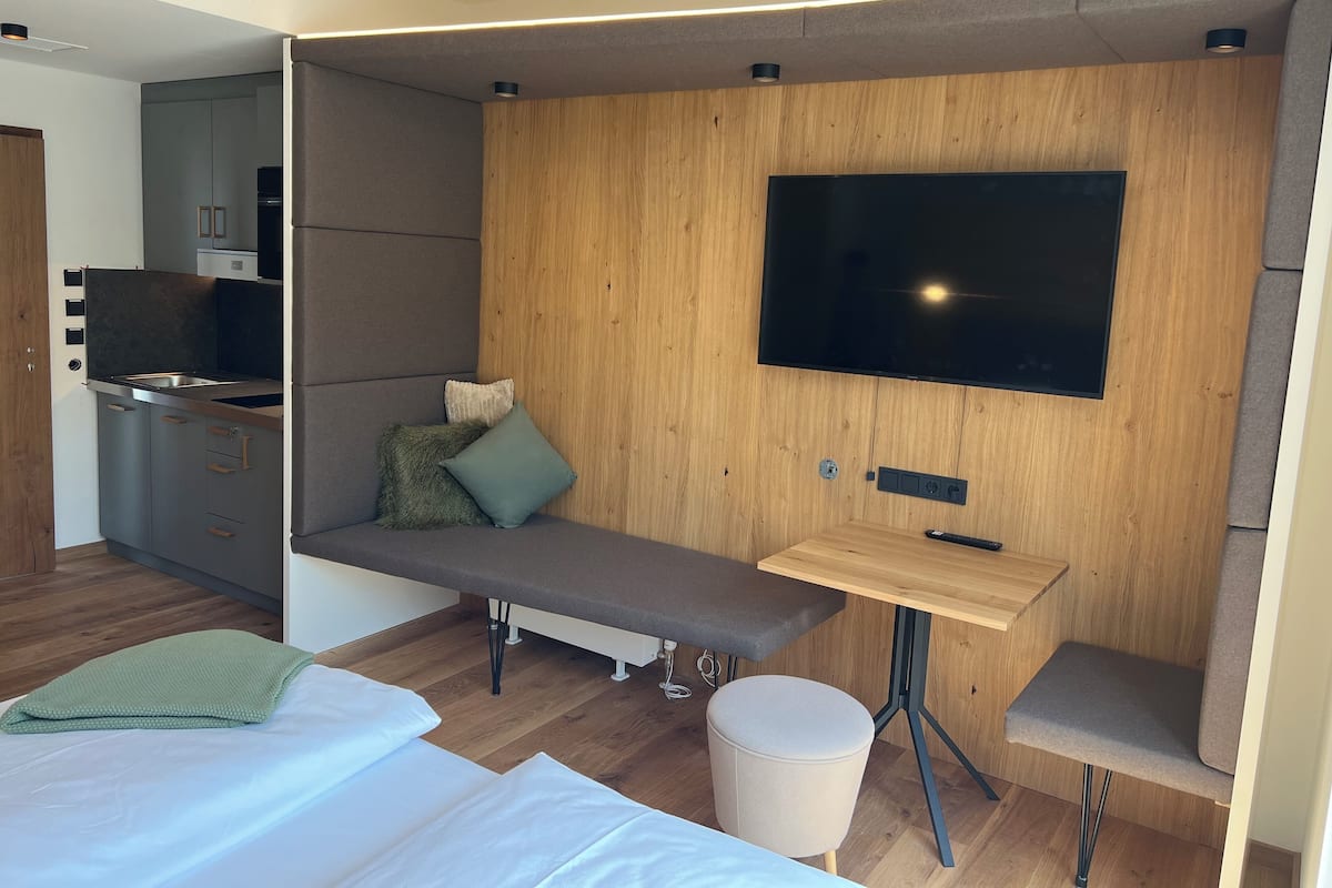Studiosuite – deluxe, ikke-røyk, balkong | Oppholdsområde | En 50-tommers Flatskjerm-TV med kabel-kanaler samt TV og kontorer