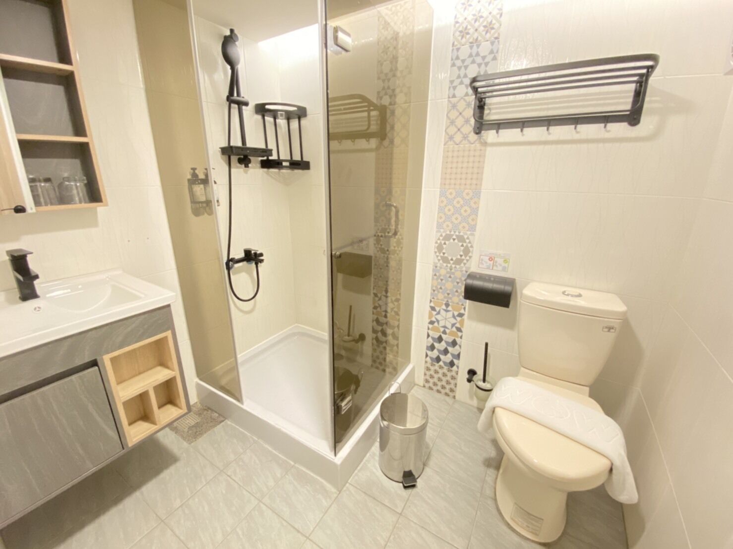 A modern bathroom with a glass-enclosed shower, a toilet, and a sink.