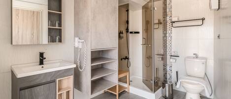 A modern bathroom with a vanity, toilet, shower, and a glass-enclosed shower area.