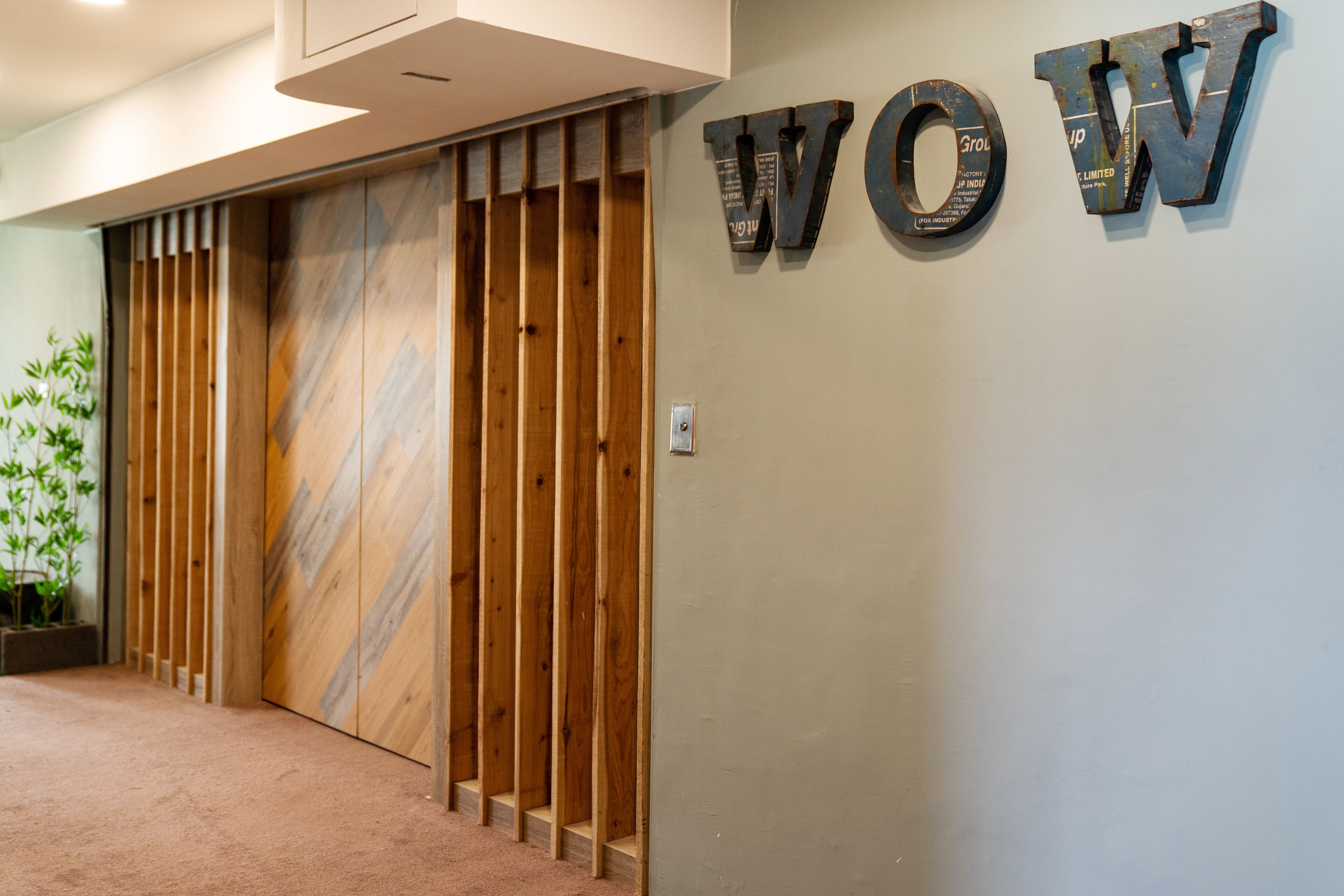 Un área de recepción con un revestimiento de listones de madera y un letrero que dice 'WOW'.