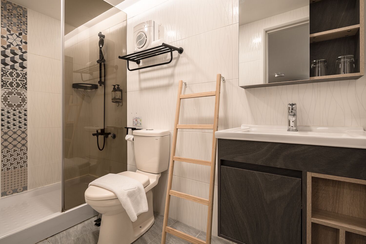 A modern bathroom with a toilet, shower, and sink.