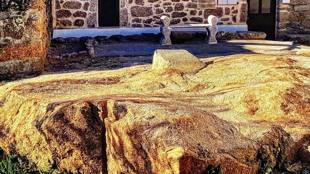 A stone building with a red-tiled roof, a stone bench, and a sign that reads "Casa Isabel de Gouveia". - House in the historic center  (BELMONTE)