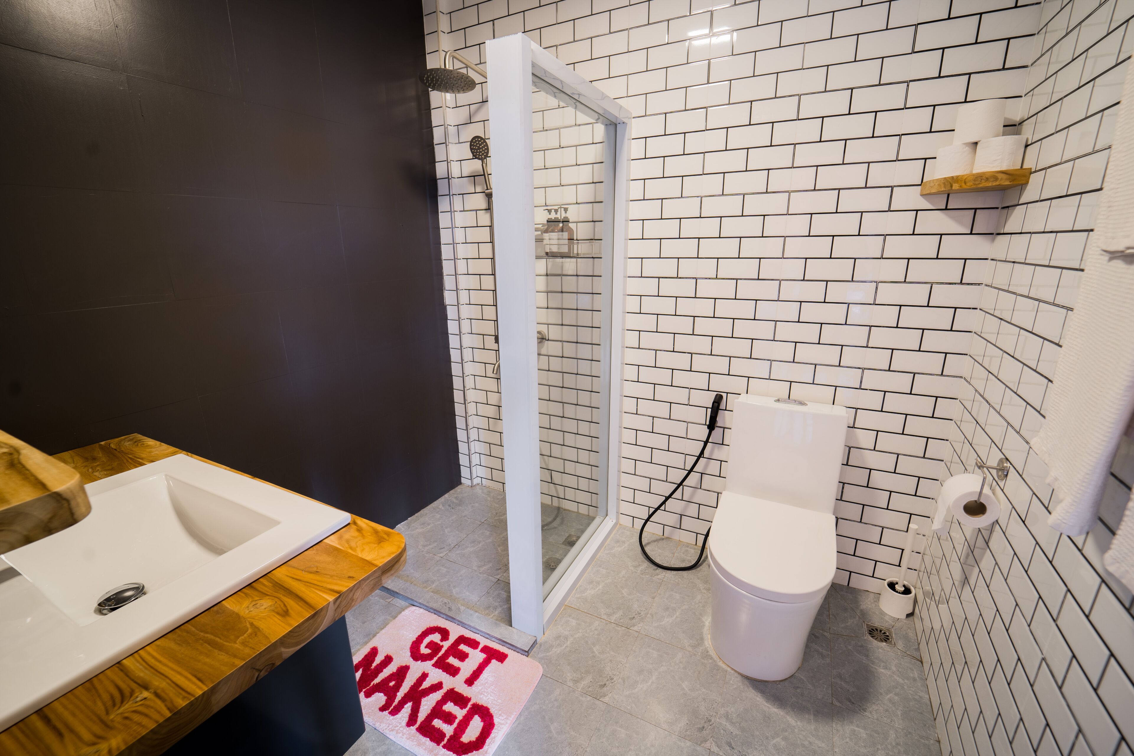 A bathroom with a white sink, a glass shower enclosure, and a toilet.