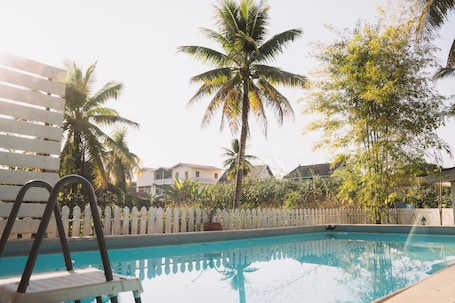 Una piscina al aire libre, sillones reclinables de piscina