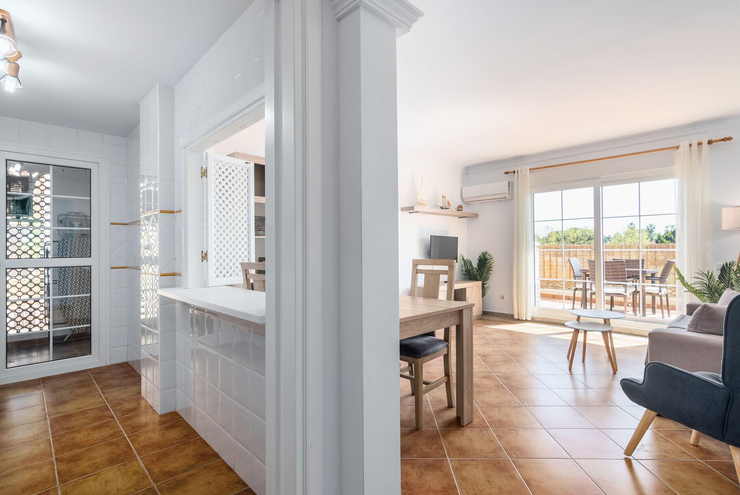 Un vaste espace de vie comprenant une table à manger, un canapé et une vue sur l’extérieur.