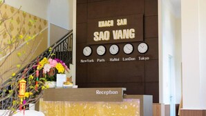 A reception desk with clocks displaying times in New York, Paris, Ha Noi, London, and Tokyo. - Hotel Sao Vàng (B'Lao)