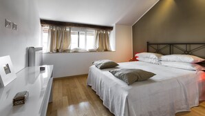 Ein Schlafzimmer mit einem Bett, einem Nachttisch, einem Fenster mit Vorhängen und einer Heizung.
