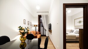 Een moderne woonkamer met een eettafel, stoelen, een bank en een televisie.