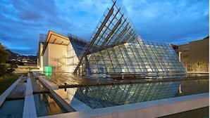 A modern building with a glass facade and a unique angular design. - Klemi (Trento)
