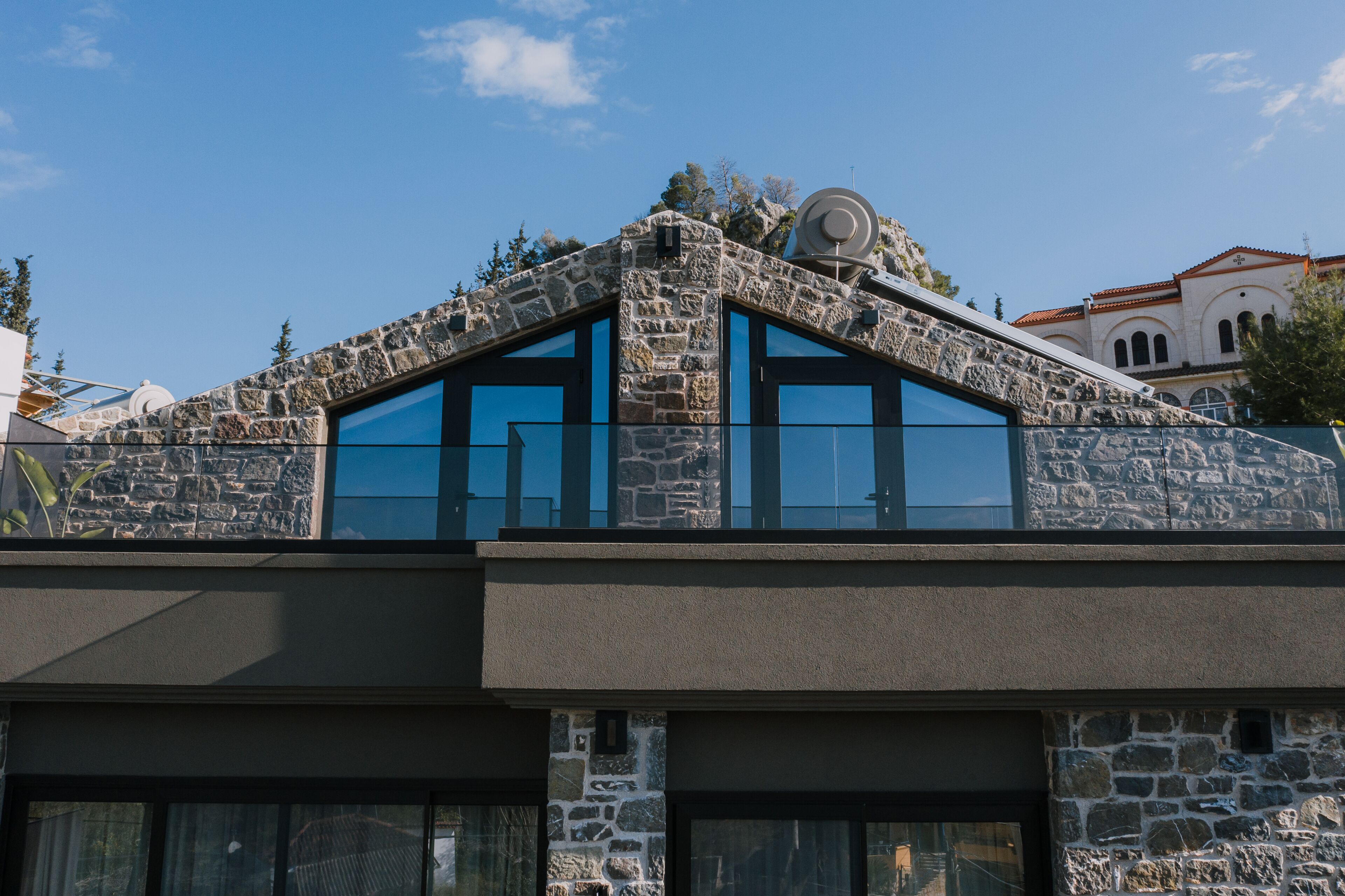 A modern building with stone facade, large windows, and a satellite dish.