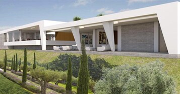 Un edificio moderno con techo plano, ventanas amplias y una zona de estar exterior cubierta.