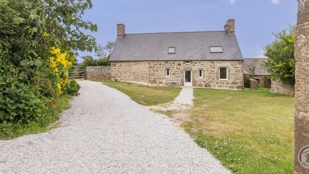 A stone farmhouse with a gravel driveway leading to a white door, surrounded by greenery and a clear sky. - Charming historical house, pets allowed, private parking (Vicq-sur-Mer)