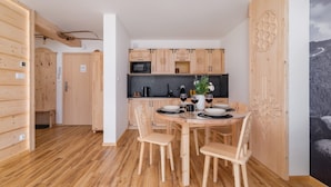 Eine moderne Küche mit Holzausstattung und einem Essbereich mit rundem Tisch und Stühlen.