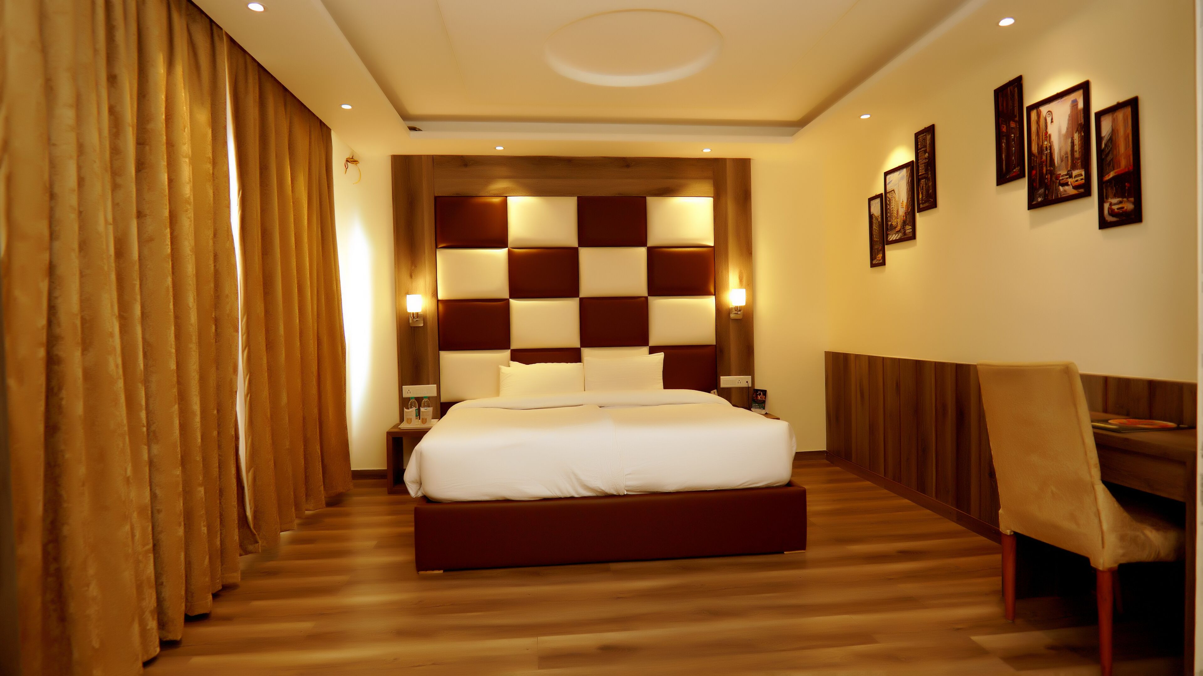 A hotel room with a large bed, wooden headboard, and a seating area with a chair.