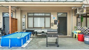 A covered outdoor area with a pool table, a grill, and a small seating area. - New Forest Living Homestay (Wujie)
