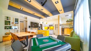 A modern living room with a pool table, dining area, kitchen, and a TV. - New Forest Living Homestay (Wujie)