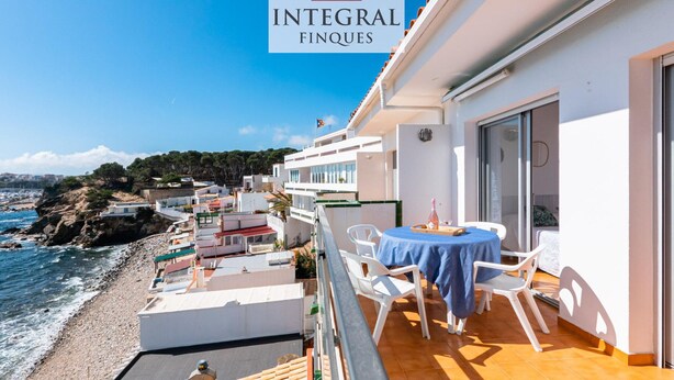 A balcony with a table and chairs overlooking a beach. - Seafront apartment with terrace, wifi, pets allowed, spectacular views (Palamós)