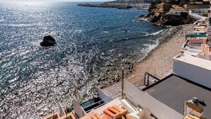 A coastal view with a rocky beach, a pier, and buildings with balconies overlooking the sea. - Seafront apartment with terrace, wifi, pets allowed, spectacular views (Palamós)