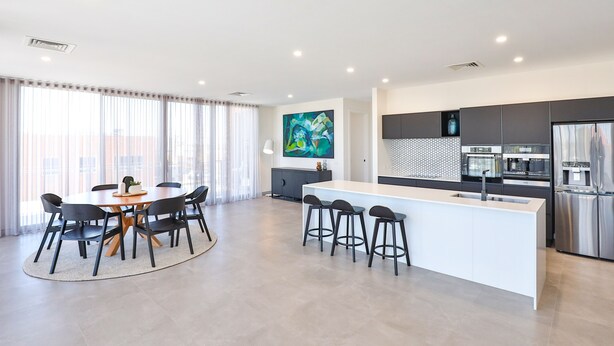 A modern kitchen with a central island, dark cabinetry, and stainless steel appliances. - Indulge Apartments City View Penthouses (Mildura)
