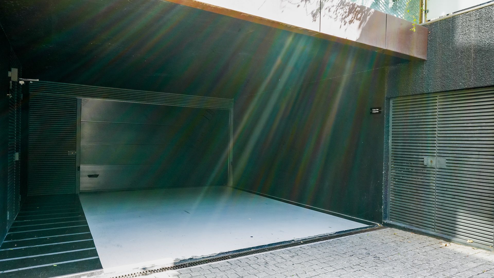 A closed garage door with a metal staircase leading to a covered entrance.