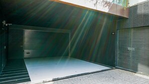 Une porte de garage fermée, avec un escalier métallique menant à une entrée abritée.