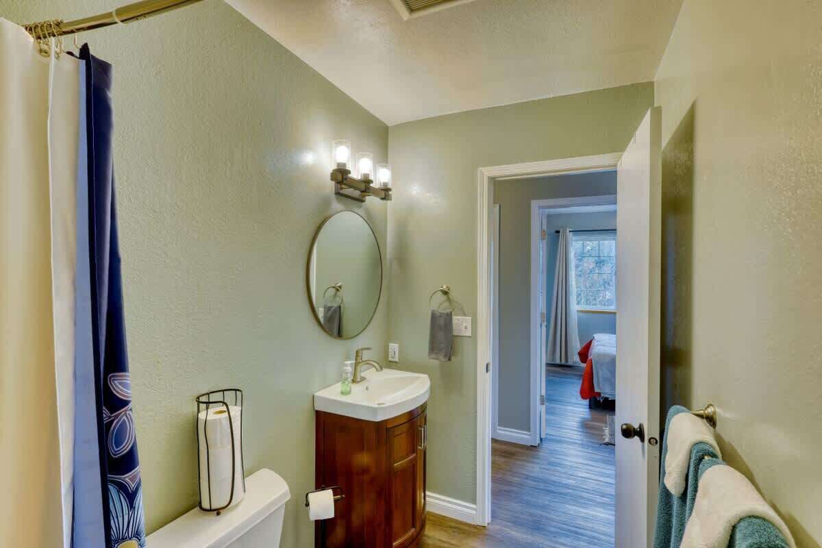 A bathroom with a toilet, sink, and mirror.