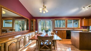 Una cocina amplia con armarios de madera, una mesa de comedor y un ventanal grande.