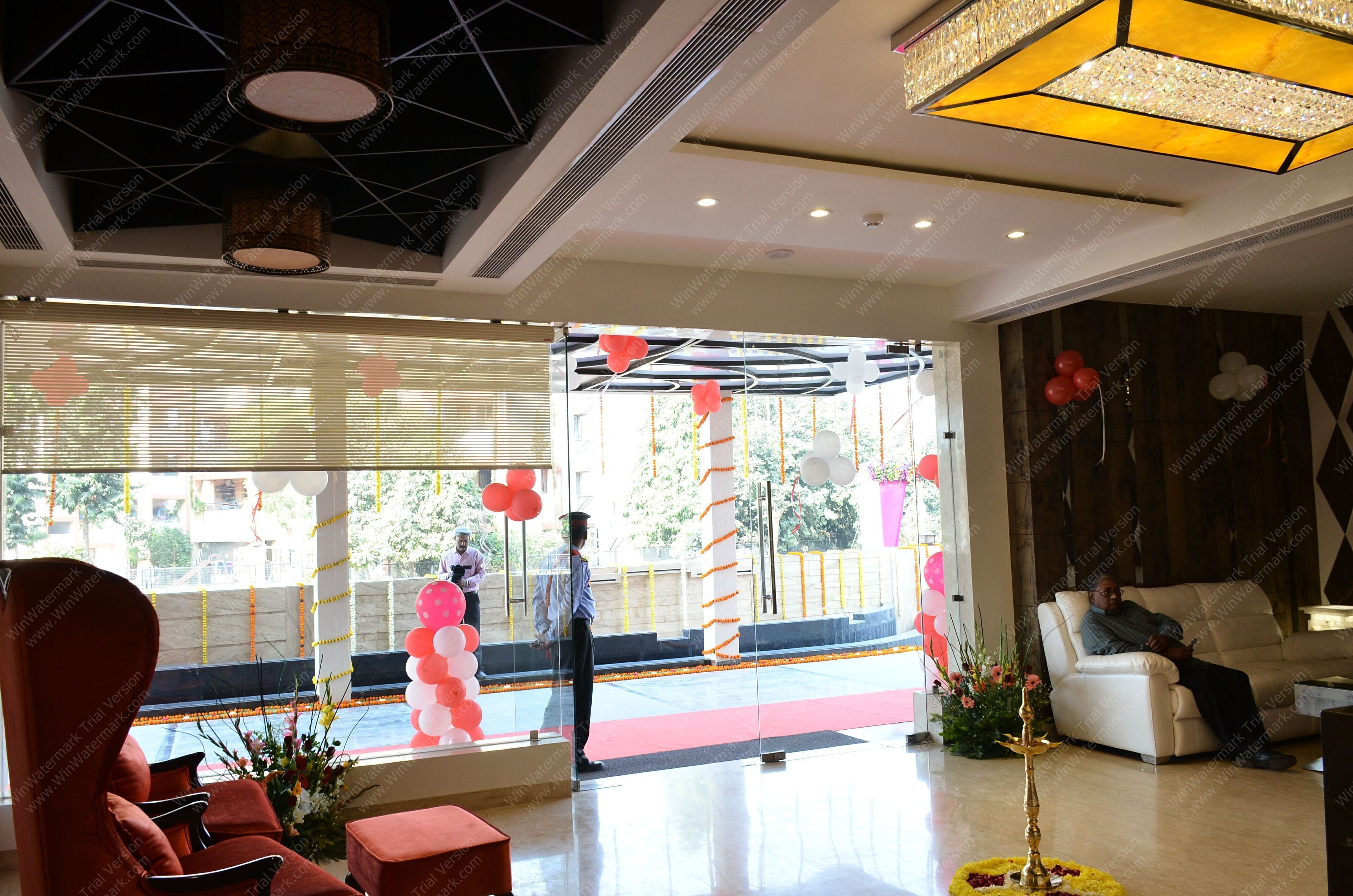 A hotel lobby with a red carpet, a white sofa, and a large window with decorative balloons.