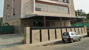 A multi-story hotel with a modern design, featuring a covered entrance and a parking area. - Hotel Ramaya  (Gwalior)