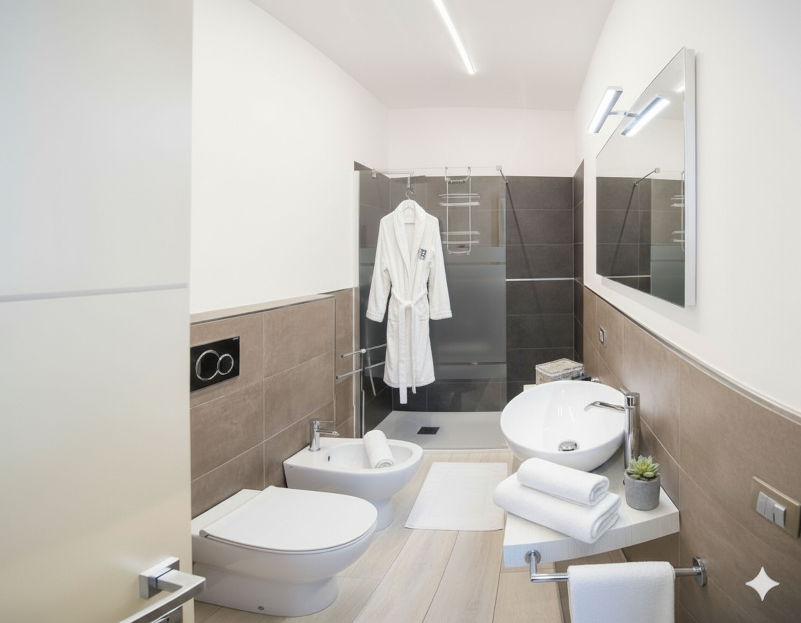 Uma casa de banho moderna com bidé, sanita, lavatório e chuveiro.