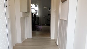 Un couloir avec un paillasson noir sur lequel est écrit : « BIENVENUE chez vous ».