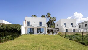A modern two-story residential building with a flat roof, large windows, and a covered patio area. - luxury holiday home in Lo Stagnone I Palm Kite Paradise I Casa A (Marsala)